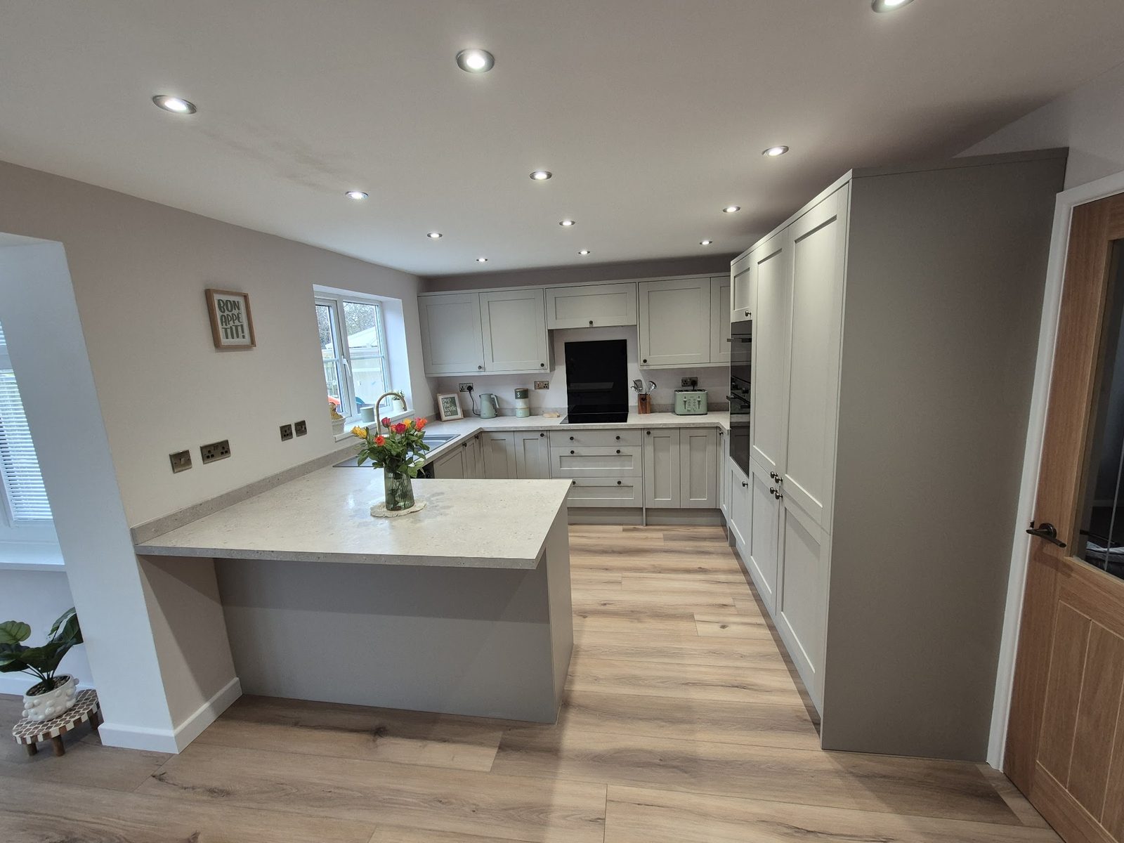 A finished light grey shaker kitchen with an island, fitted by Jackson's Joinery & Fencing